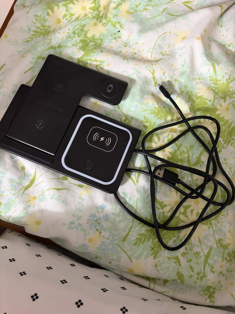 Leah's Halo 3-in-1 foldable charging pad laid out on floral sheets with its charging cable