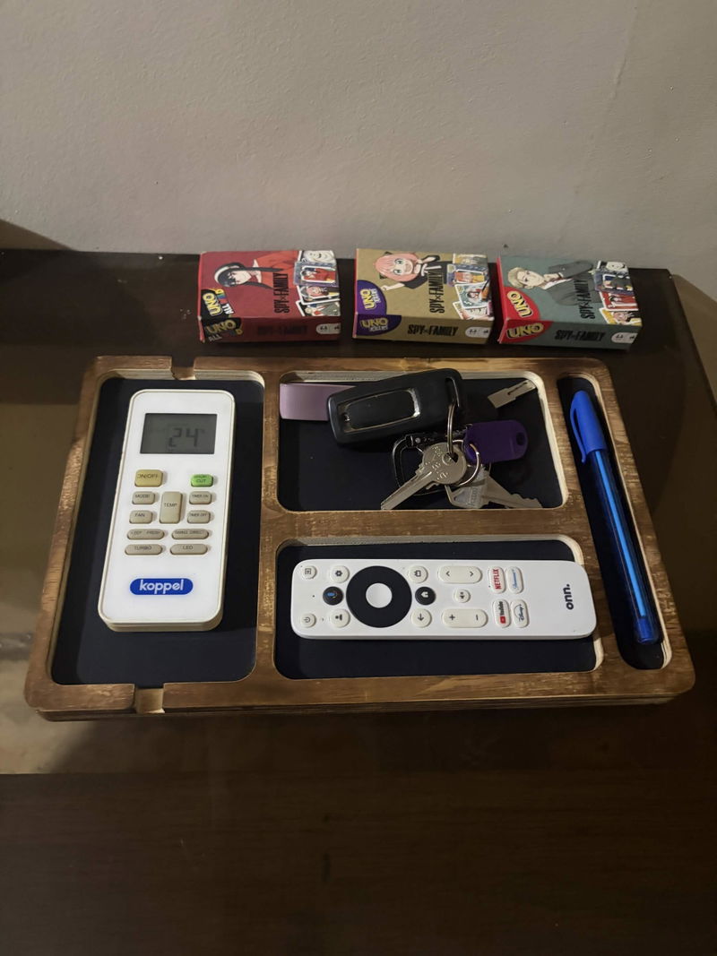 Mark V.'s Nox valet tray in the living room, holding the aircon remote, house keys, a TV remote, and a pen