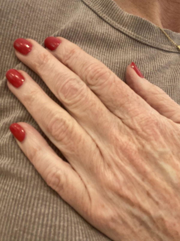 Tahnee’s hand with glossy true red Dazzle Dry nails