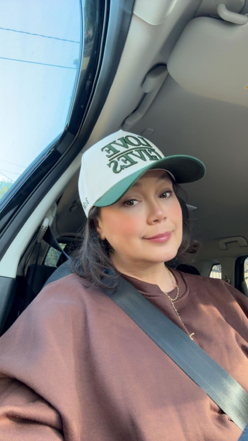 Customer in a Dark Green LOVE GIVES hat in her car