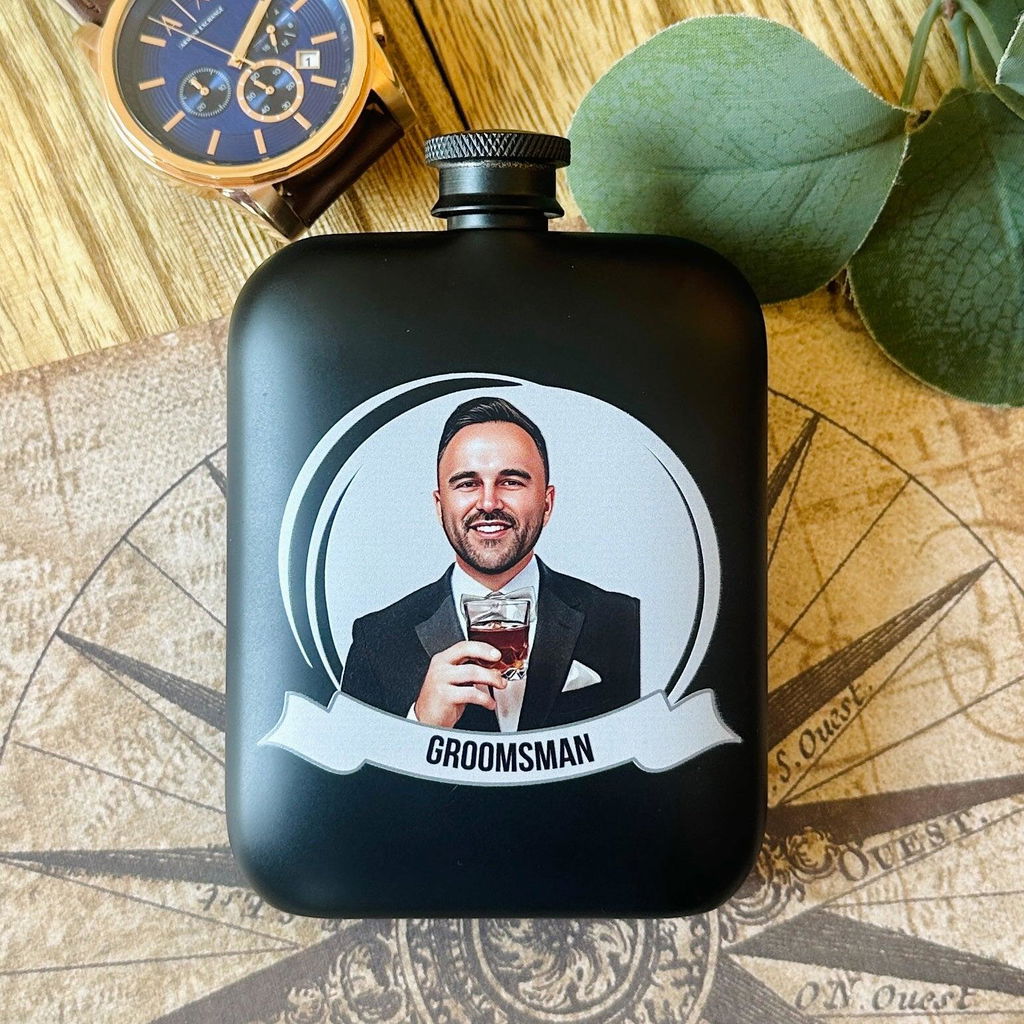 The Groomsmen Grins Personalized Photo Flask from Groovy Groomsmen, a five star reviewed groomsmen gift featuring a custom illustrated portrait of the recipient.