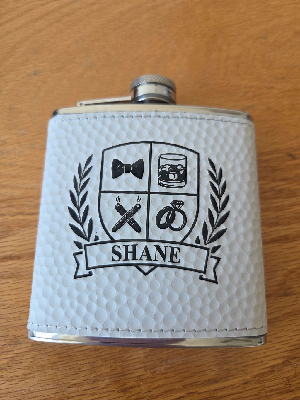 Customer photo of the personalized Groomsmen Crest Flask engraved with the name Shane, shared in a five star review by Sam S. for Groovy Groomsmen.