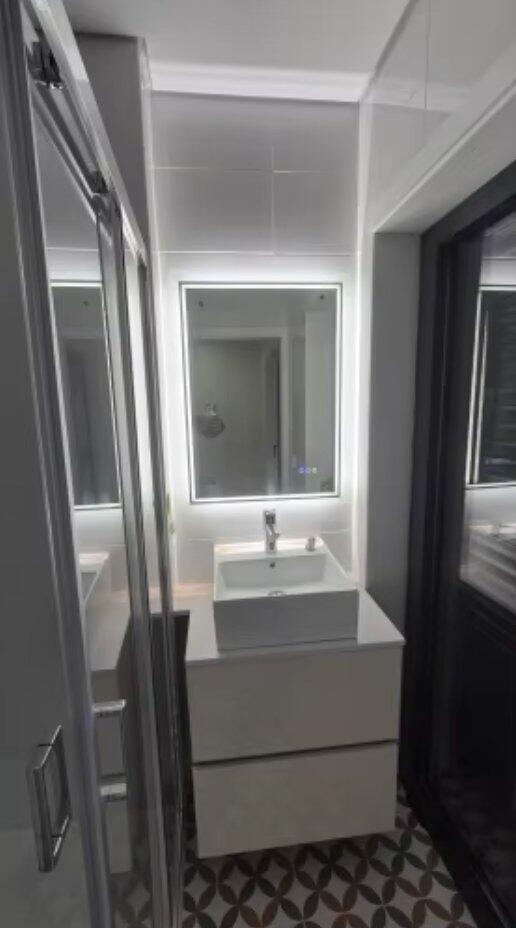 Customer photo of an illuminated rectangular mirror in a narrow bathroom