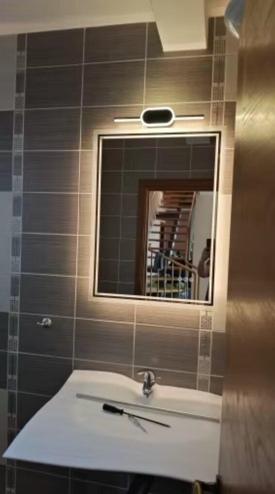 Customer photo of a rectangular mirror with warm backlighting above a basin