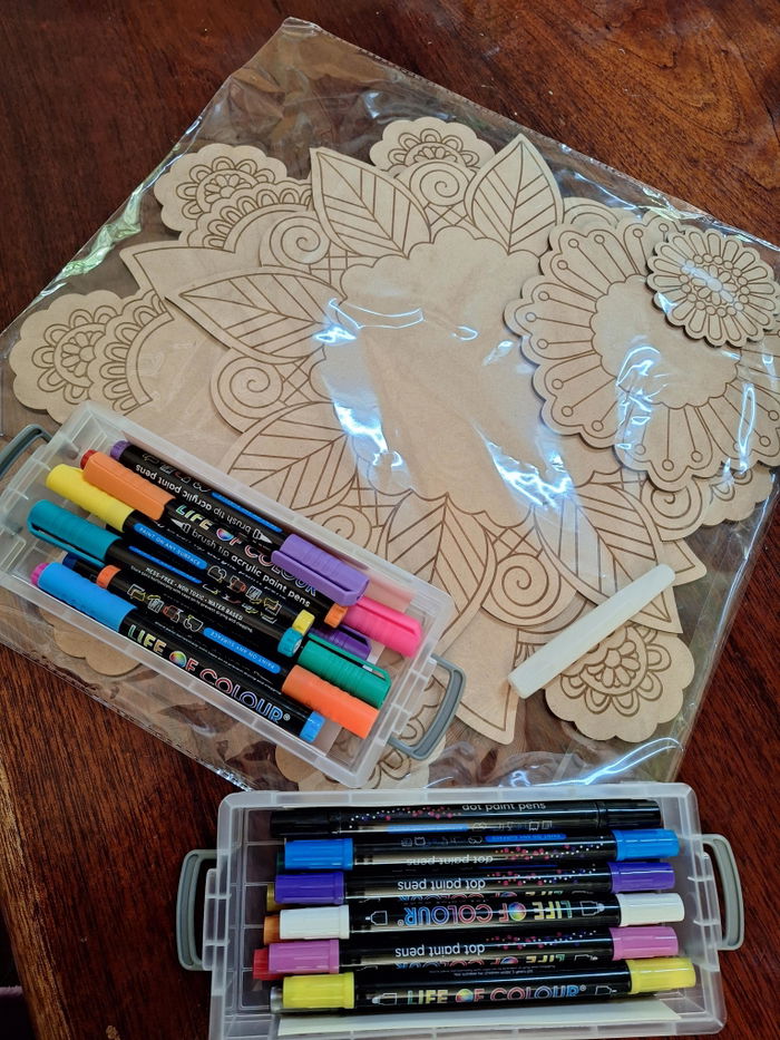An unpainted engraved board next to Life of Colour pens