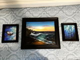 A home gallery wall with framed landscape and symbolic paintings.