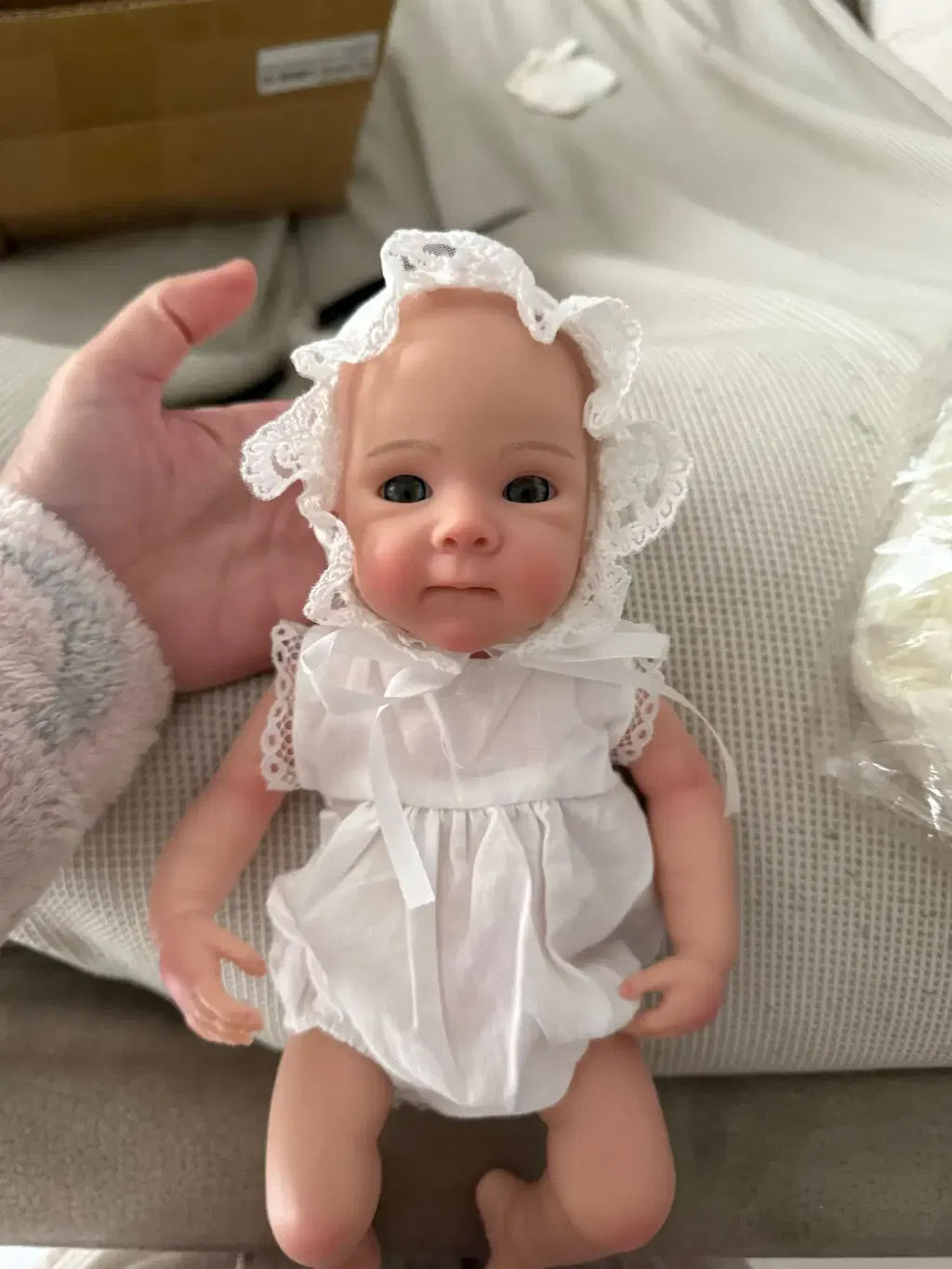 Bambola reborn Bettie da 30cm in silicone con pelle dipinta in 3D e vestitino di pizzo bianco
