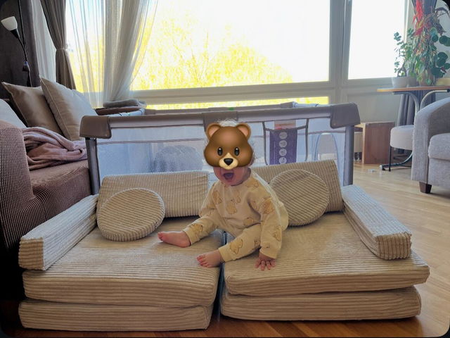 Kleinkind im B&auml;renkost&uuml;m sitzt auf dem Spielsofa