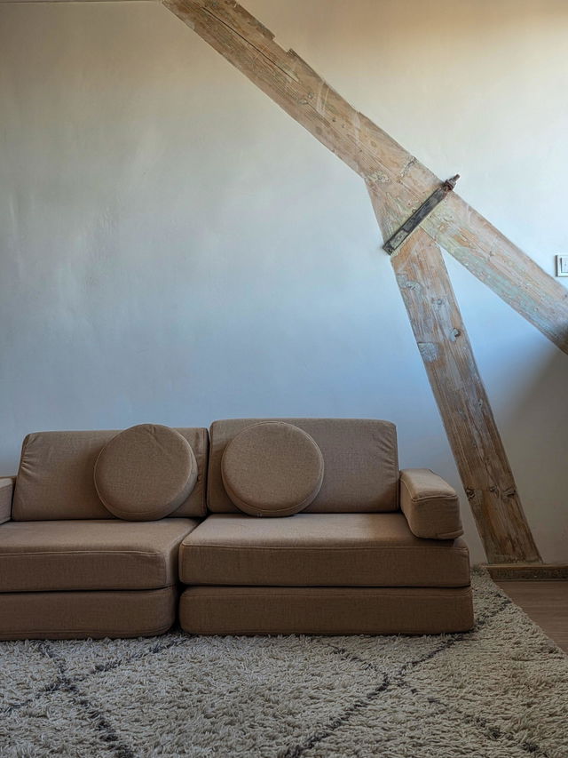 Camelfarbenes Spielsofa unter einer Dachschr&auml;ge