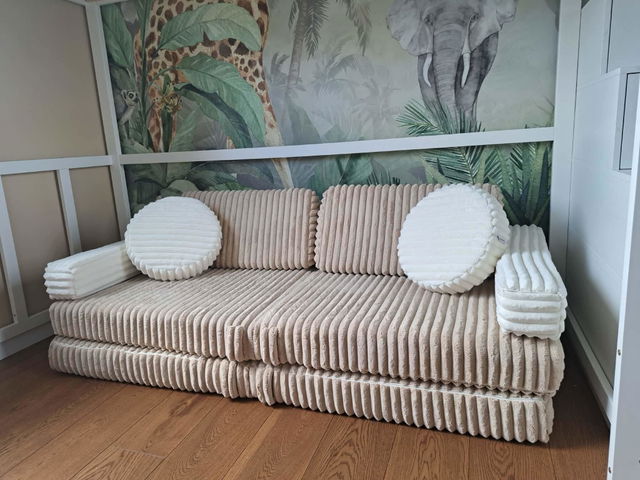 Beiges Spielsofa als Sofa vor einer Dschungeltapete