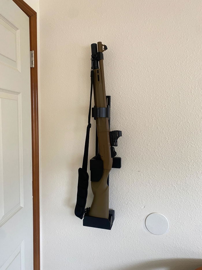 An owner's Beretta 1301 with an FDE stock and a red dot locked in a RACT beside a door