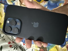 Buyer’s photo: back of a dark iPhone 15 Pro Max in a case, held in hand