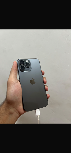 Buyer’s photo: back of a black titanium iPhone 15 Pro Max, held in hand