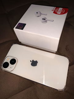 Buyer’s photo: white iPhone 13 in a clear case next to the AirPods Pro box that came free with it
